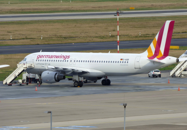 Germanwings Airbus A320-200 geparkt am Frankfurt Airport mit Bodenfahrzeugen, Verkehrskegeln, Pfählen und Gras im Hintergrund.