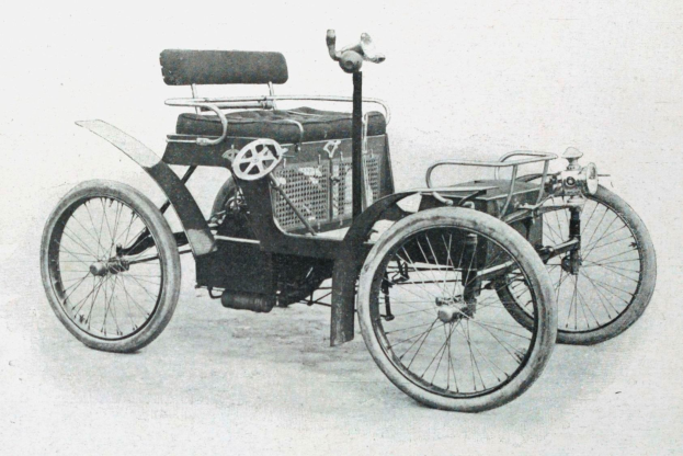Schwarzes und weißes Foto eines Elektroautos aus den frühen 1900er Jahren mit schlankem, aerodynamischem Design, großem runden Scheinwerfer, geschwungener Dachlinie, vier großen Rädern und einem prominenten Heckmotor.