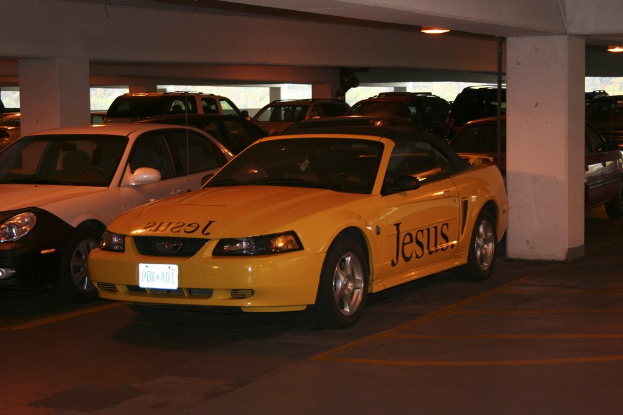 Ein vollbesetzter Parkplatz mit vielen Autos vor einem Gebäude.