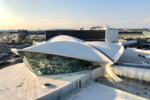 Luftaufnahme des neuen Terminalgebäudes am Los Angeles International Airport mit umgebenen Infrastruktur, Fahrzeugen und bewölktem Himmel.