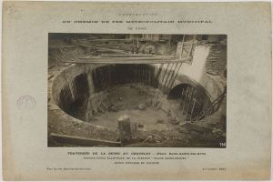 Schwarz-weiß-Foto eines Tunnelbaus mit einem Stempel auf der linken Seite und Text unten.