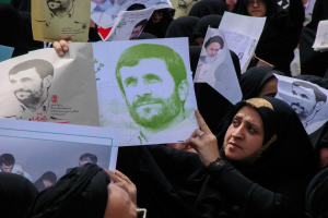 Eine Gruppe iranischer Frauen in schwarzer Kleidung, einige mit Brille, halten Bilder von Präsident Mahmoud Ahmadinejad während einer Kundgebung in Tehran hoch.