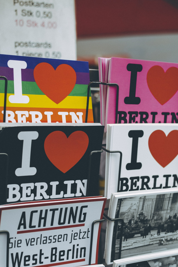 Ein Gestell mit verschiedenen Büchern und Postern mit der Aufschrift "Ich Liebe Berlin" vor einem unscharfen, verträumten Hintergrund.