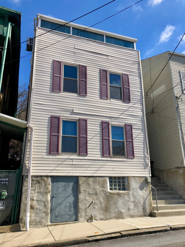 Ein zweistöckiges Gebäude mit violetten Fensterläden, Fenstern und einer Tür, das auf einer Straße mit Treppen steht, umgeben von Bäumen und einem bewölkten Himmel, mit Text unten, der 'Mietwohnungen zur Miete, listingid 29058910, location 59 Elmwood Ave Yonkers 10701' liest.