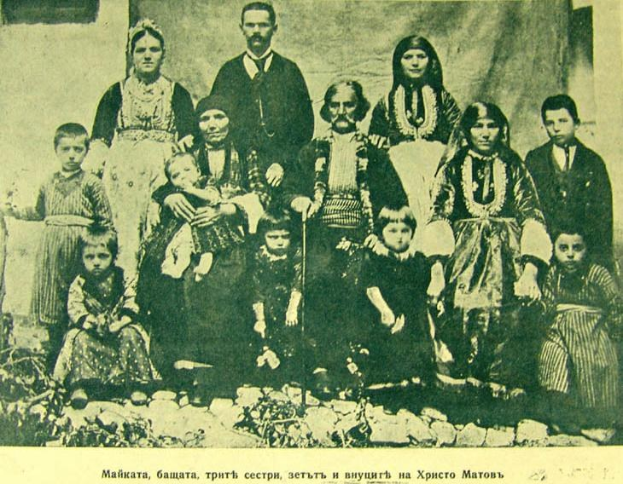 Schwarz-weiß-Foto einer Familie, die vor einer Vorhangwand posiert, beschriftet mit "Russische Familie in den frühen 1900er Jahren".