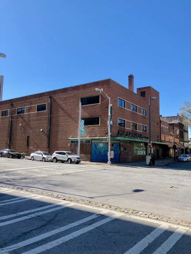 Leere Straße mit parkenden Autos, Laternen, Schildern und Gebäuden mit Fenstern, Bäume im Hintergrund unter einem klaren blauen Himmel, Gewerbeobjekt zum Verkauf an 715 W Main St, Chicago, Illinois 60611, USA.