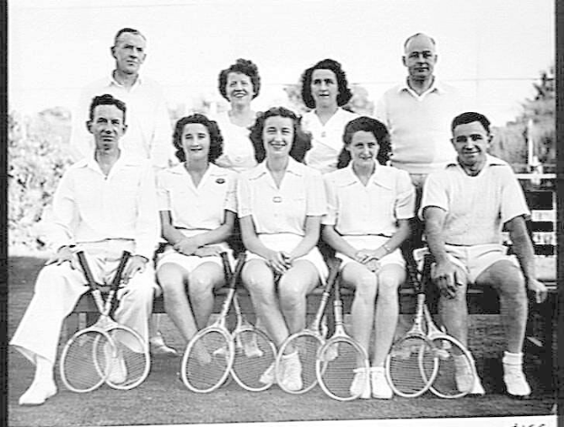 Schwarzes Foto einer Gruppe von Menschen, die strahlend Tennisrackets halten und auf einer Bank sitzen, mit Bäumen und einem klaren Himmel im Hintergrund und dem Text "Tennis Hall of Fame" unten.