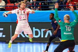 Männer bei einem Handballspiel während der Futsal-Weltmeisterschaft 2019 zwischen Bayern München und Paris Saint-Germain, mit Zuschauern im Hintergrund.