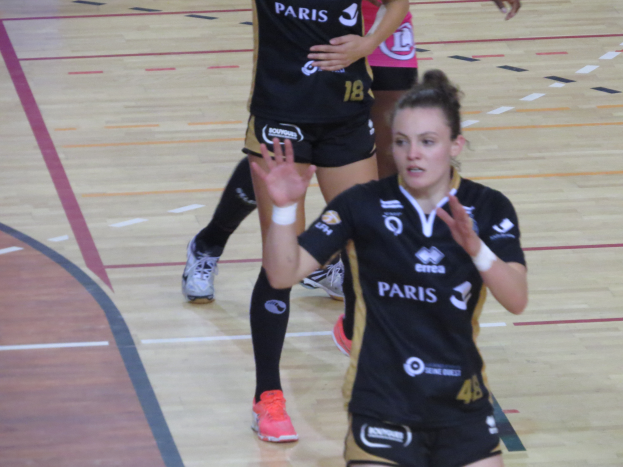 Eine Gruppe von Frauen in Sportkleidung spielt Volleyball auf einem Feld.