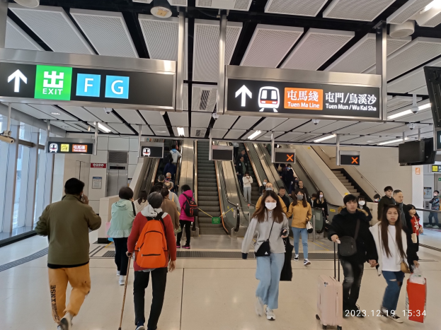 Menschen mit Gepäck durch einen geschlossenen Flughafen gehen, Rolltreppen, Informationsanzeigen, Deckenleuchten und Glaswände sind zu sehen.